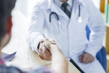 Crop doctor and patient shaking hands in office