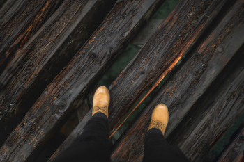Crop legs on wooden bridge