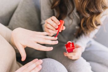 Crop woman polishing nails of friend Crop woman polishing nails of friend