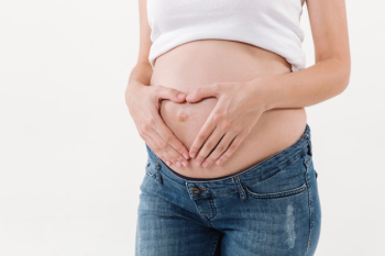 Cropped image of pregnant woman holding her hands on tummy Free Photo