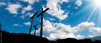Crosses Silhouette against Blue Sky / Silhouette of three crosses against a blue sky with clouds and sun rays. Carisolo Trentino Italy