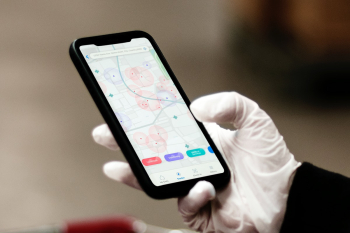 Crowd alert COVID-19 phone mockup psd person wearing gloves while holding the device