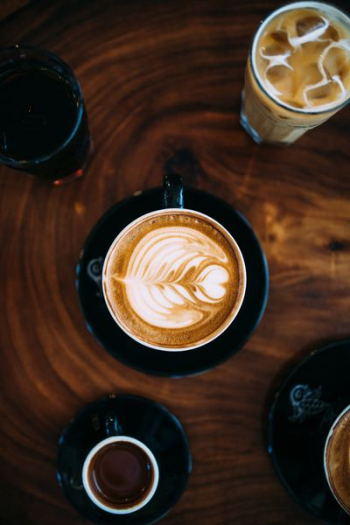 cup coffee with milk frothed on brown tabletop cup coffee with milk frothed on brown tabletop