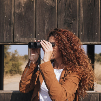 Curly redhead woman watching through binoculars Free Photo Curly redhead woman watching through binoculars Free Photo