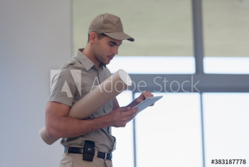 Delivery man with digital tablet and tube package