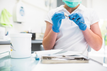 Dental technician applying ceramics to teeth Dental technician applying ceramics to teeth