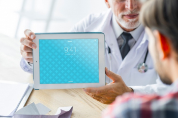 Doctor showing tablet to patient Free Psd