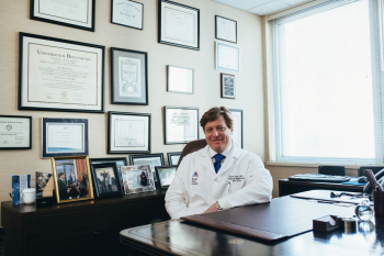 Doctor Sitting in Front of His Desk Doctor Sitting in Front of His Desk