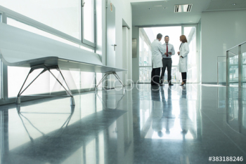Doctors and administrator talking in hospital corridor Doctors and administrator talking in hospital corridor