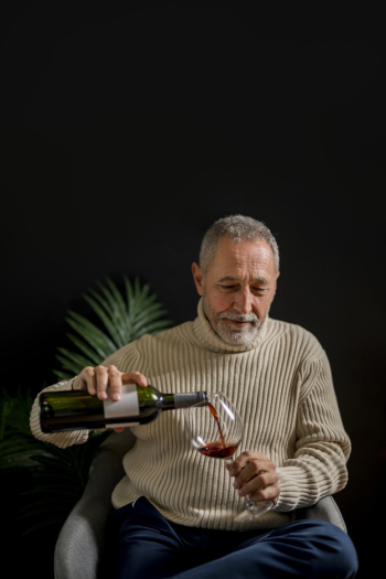 Elderly male pouring wine Elderly male pouring wine