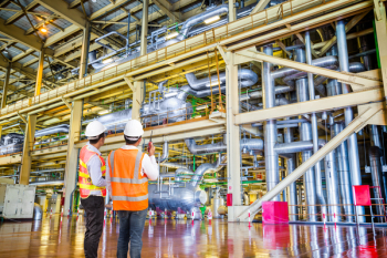 Engineer working in a thermal power plant with talking on the walkie-talkie for controlling work