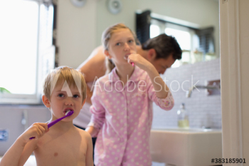 Family brushing teeth in bathroom