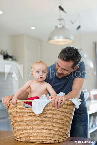 Father and baby son in laundry basket Father and baby son in laundry basket
