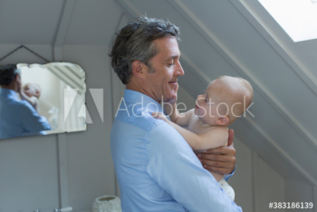 Father holding curious baby son Father holding curious baby son