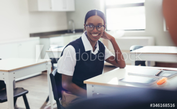 Female student sitting at desk in classroom Female student sitting at desk in classroom