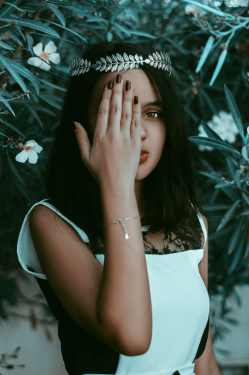 Fine art fairy tale portrait of a gorgeous model  hiding her right eye with her hand.