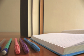 Five Assorted-color Pens Beside Blue Lined Paper Five Assorted-color Pens Beside Blue Lined Paper