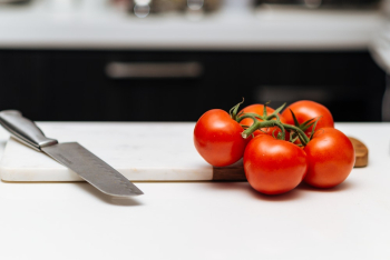 Five Tomatoes on Chopping Board Five Tomatoes on Chopping Board