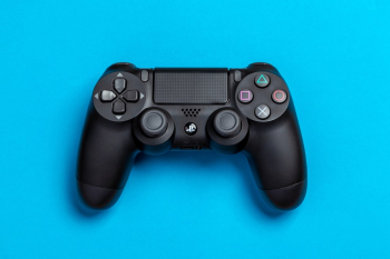 Flat Lay Photo of Black Sony PS4 Game Controller on Blue Background Flat Lay Photo of Black Sony PS4 Game Controller on Blue Background