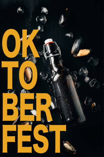 Flat lay with bottle of beer, mussels and ice cubes arranged on dark tabletop with &quot;oktoberfest&quot; lettering