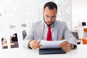 Focused businessman reading contract Free Photo Focused businessman reading contract Free Photo