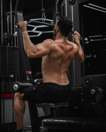 Focused Man Executing Pull-Ups in Gym Focused Man Executing Pull-Ups in Gym