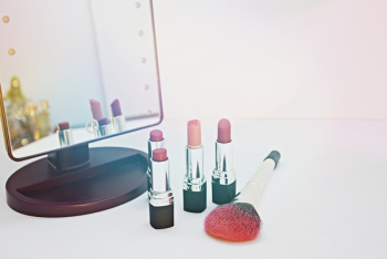 Four Assorted-color Lipsticks Beside Makeup Brush