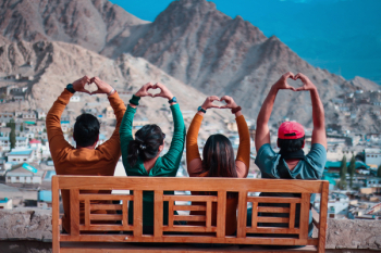 Four People Making Heart Hand Sign While Sitting Four People Making Heart Hand Sign While Sitting