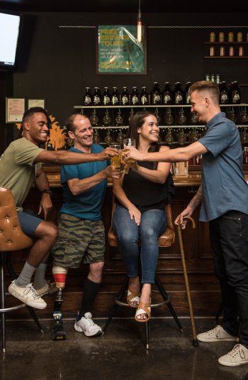 Four People Smiling Holding Glasses with Drinks Four People Smiling Holding Glasses with Drinks