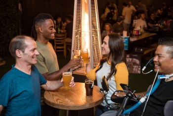 Four Smiling People Beside Table With Drinks Four Smiling People Beside Table With Drinks