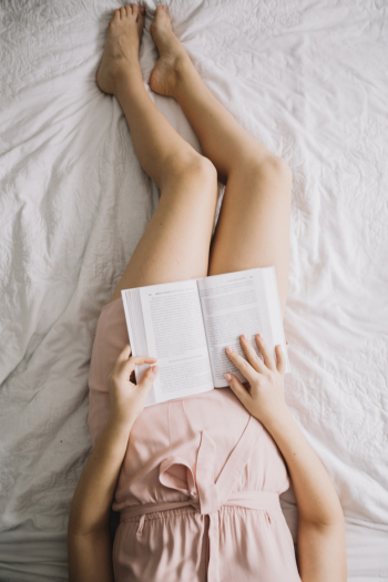 From above woman reading book on bed From above woman reading book on bed