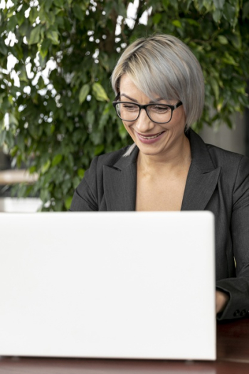 Front view business woman working on laptop Free Photo