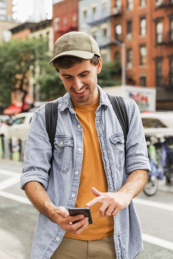 Front view man using mobile in city Free Photo