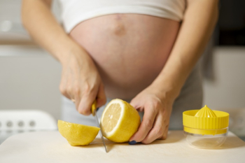 Front view pregnant woman hands cutting a lemon Free Photo