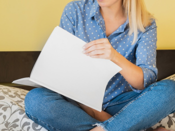 Front view woman holding a mock-up magazine Free Photo