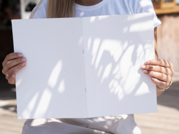 Front view woman holding a mock-up magazine Free Photo