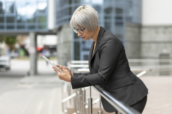 Front view woman outdoor looking on tablet Free Photo