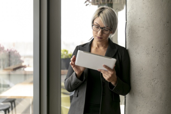 Front view woman standing and holding tablet Free Photo