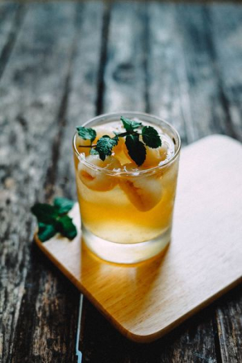 fulled clear rock glass top with green leaf on brown coaster fulled clear rock glass top with green leaf on brown coaster