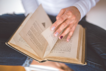 Girl thumbs through the old book Girl thumbs through the old book