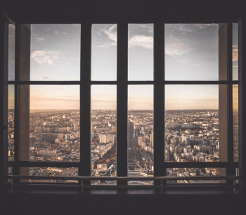 glass panel window showing city buildings under blue sky glass panel window showing city buildings under blue sky