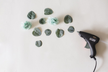 Glue Gun Beside Green Leaves and Flower on White Surface Glue Gun Beside Green Leaves and Flower on White Surface