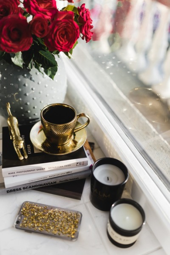 Gold cup of coffee and red roses bouqet Gold cup of coffee and red roses bouqet