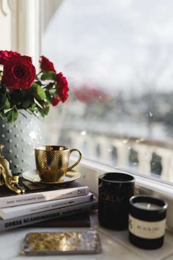 Gold cup of coffee and red roses bouqet Gold cup of coffee and red roses bouqet