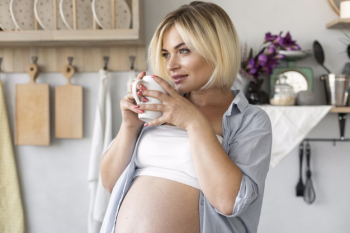 Gorgeous pregnant woman holding a cup of tea Free Photo