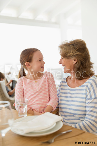 Grandmother and granddaughter talking at able Grandmother and granddaughter talking at able