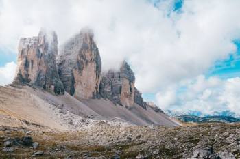gray and brown rock formation under white clouds gray and brown rock formation under white clouds