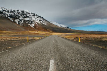 gray asphalt road under cloudy sky gray asphalt road under cloudy sky