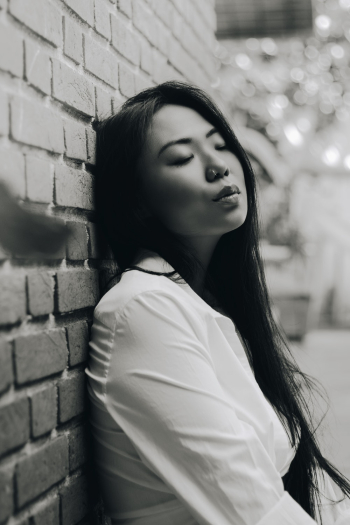 Grayscale Photo of a Woman Leaning on a Wall Grayscale Photo of a Woman Leaning on a Wall