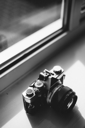 Grayscale Photo of Classical Camera Near Window Grayscale Photo of Classical Camera Near Window